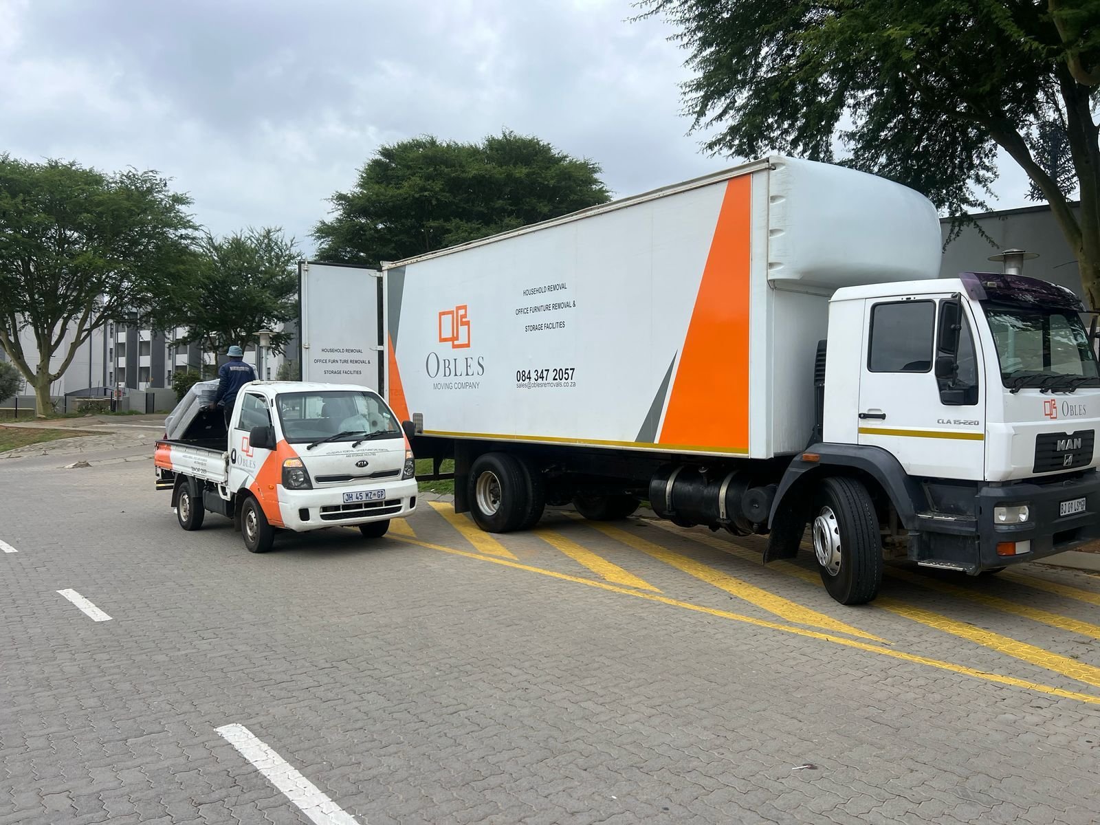 Small and large Obles Removals trucks parked together during a move
