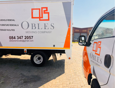 Close-up of Obles Removals branded trucks parked together