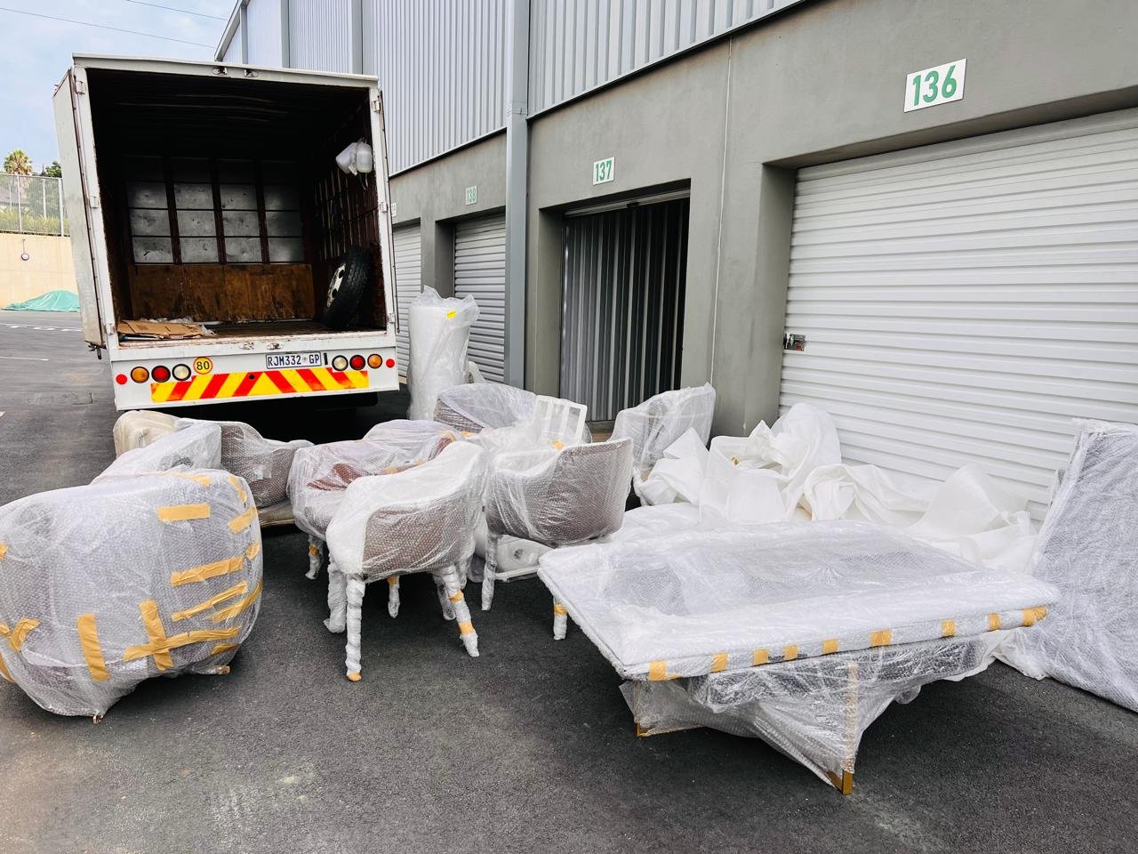 Wrapped household furniture placed outside storage units before loading