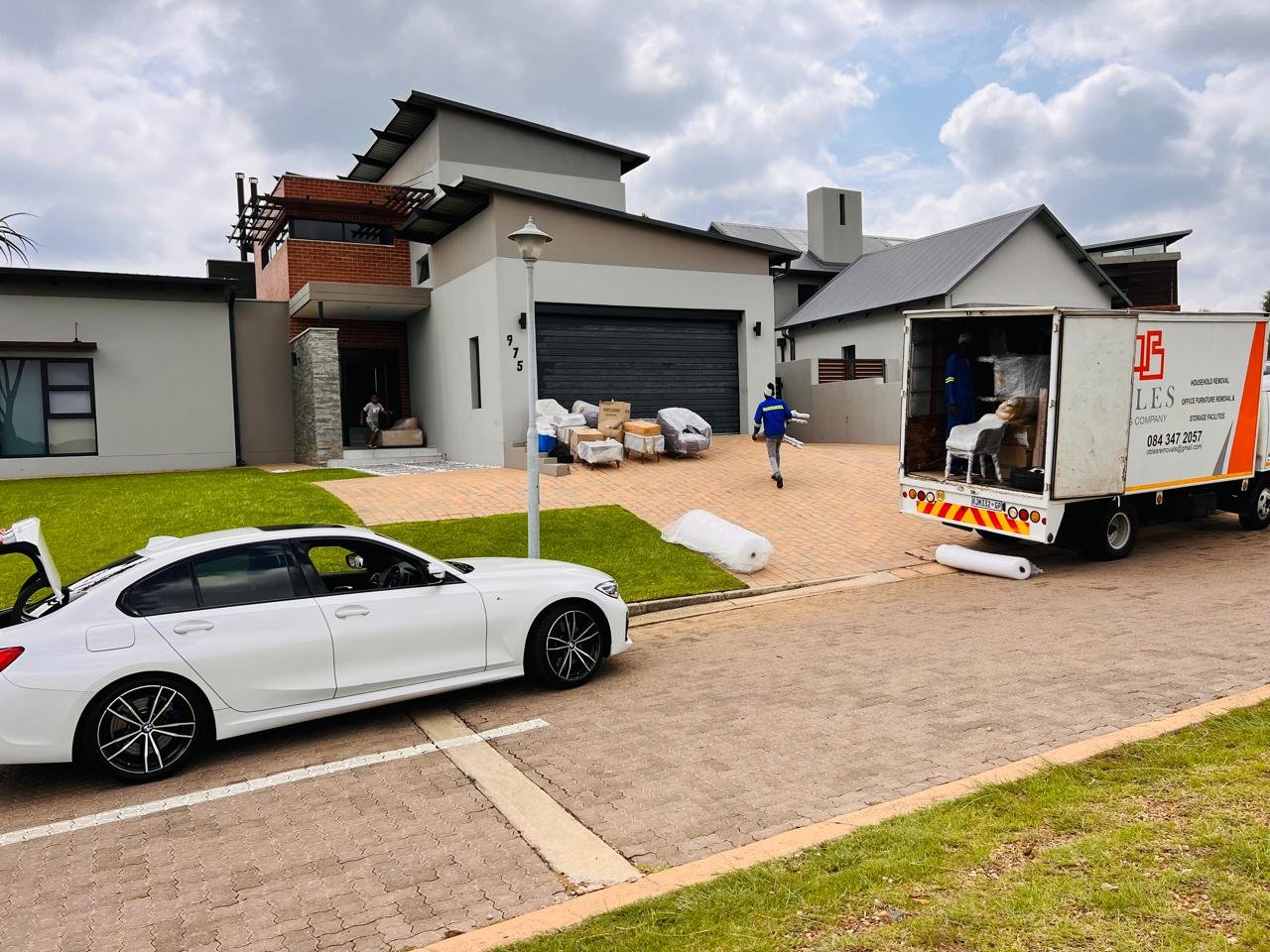Obles Removals crew unloading wrapped furniture at a residential property