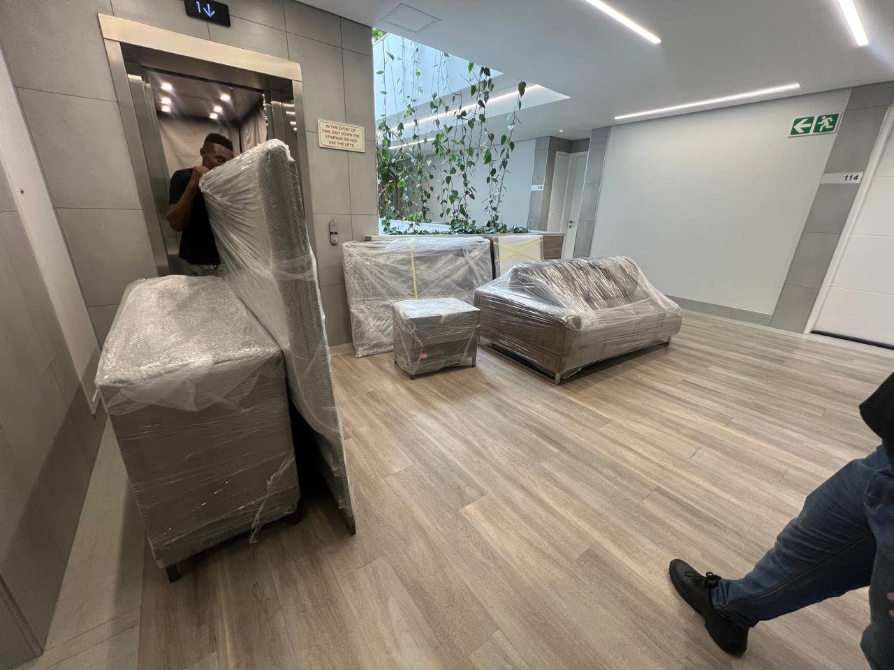 Wrapped lounge furniture positioned in a building corridor during a move