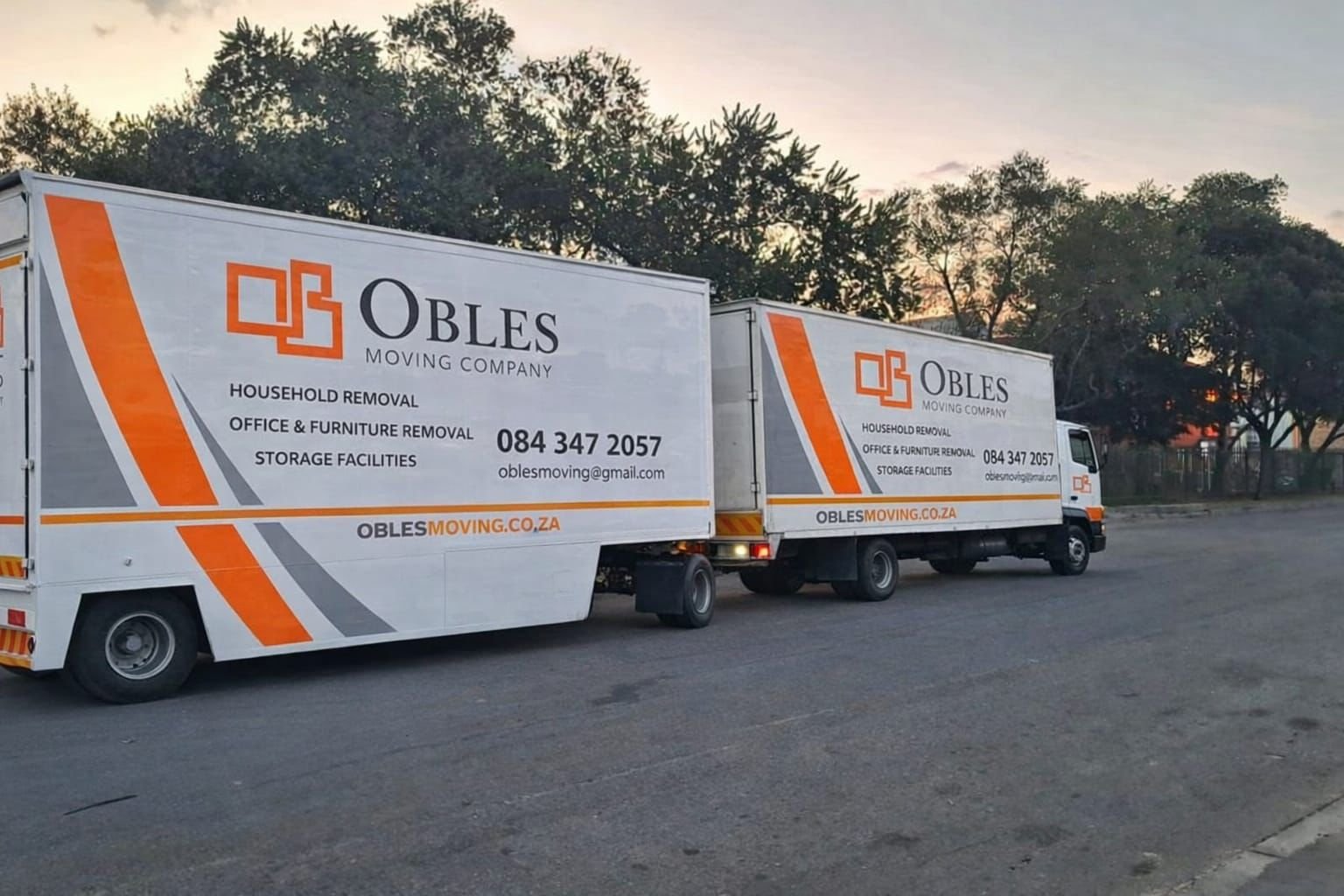 Large covered truck and Obles Removals vehicle parked on a residential street